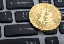 bitcoin coin on top of a keyboard