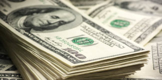 Dollar bills stacked on top of more dollar bills