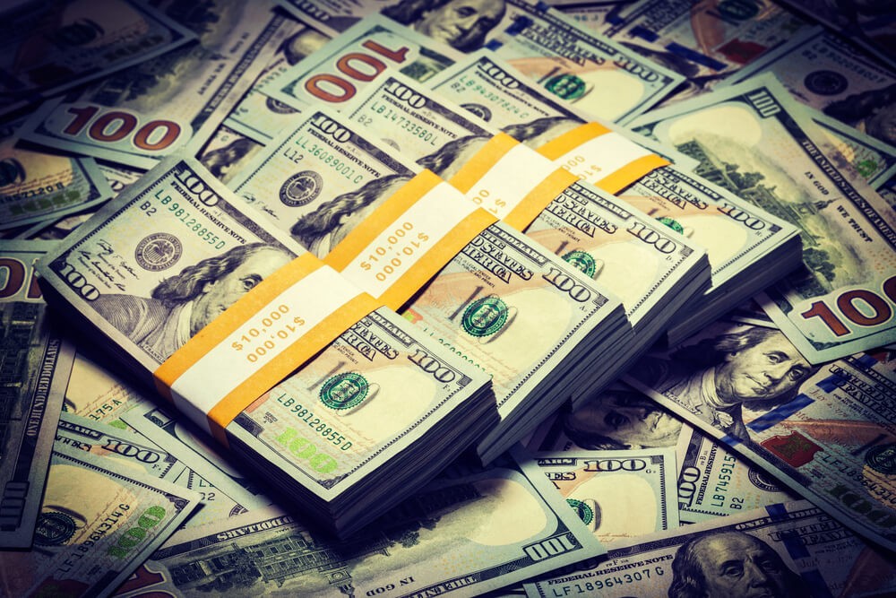 US dollar bills piled alongside each other