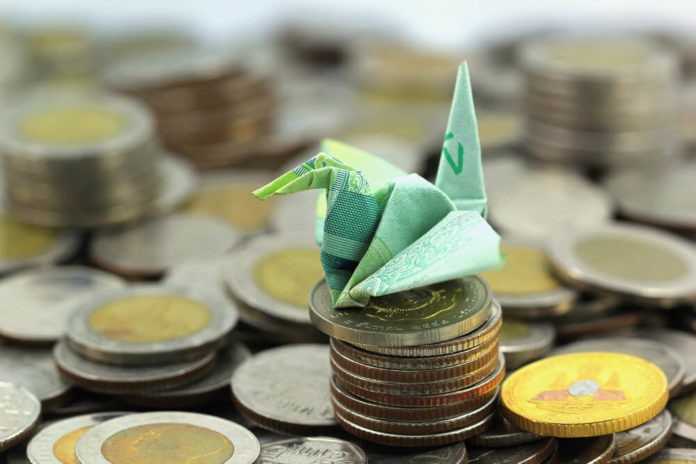 paper origami on top of coins concept exchange rates