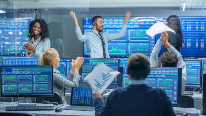 day traders in front of computers and terminals for trading