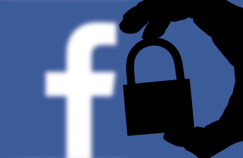 Wibest Broker-Facebook Network: a silhouette of a hand holding a padlock with Facebook logo on the background
