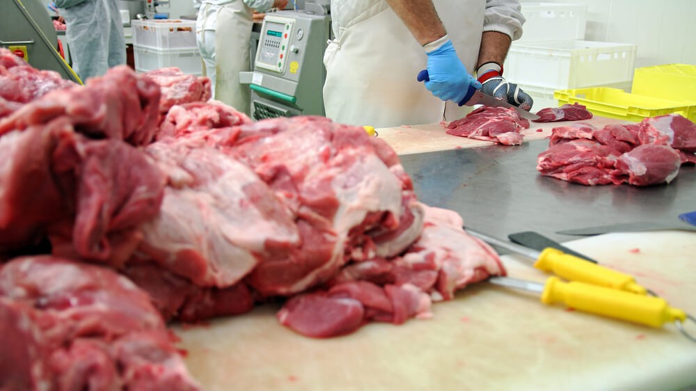 Wibest Broker — African: Butcher Cutting Pork Meat in Meat Processing Plant.