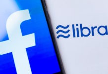 Wibest - Photo of the Facebook logo on the smartphone screen and the brochure with Libra logo.