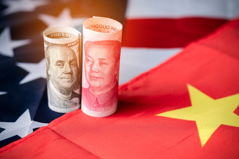 Wibest – Yuan: A greenback and a yuan bill on top of the US and Chinese flags.