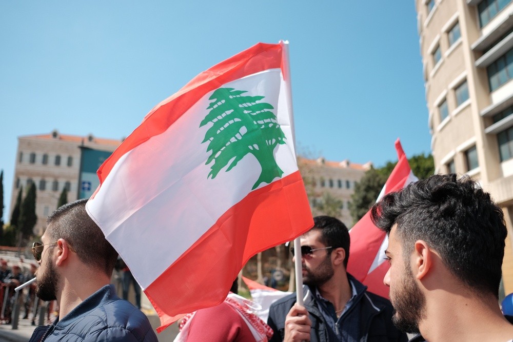 Wibest – Lebanese: A man carrying the Lebanese flag. 