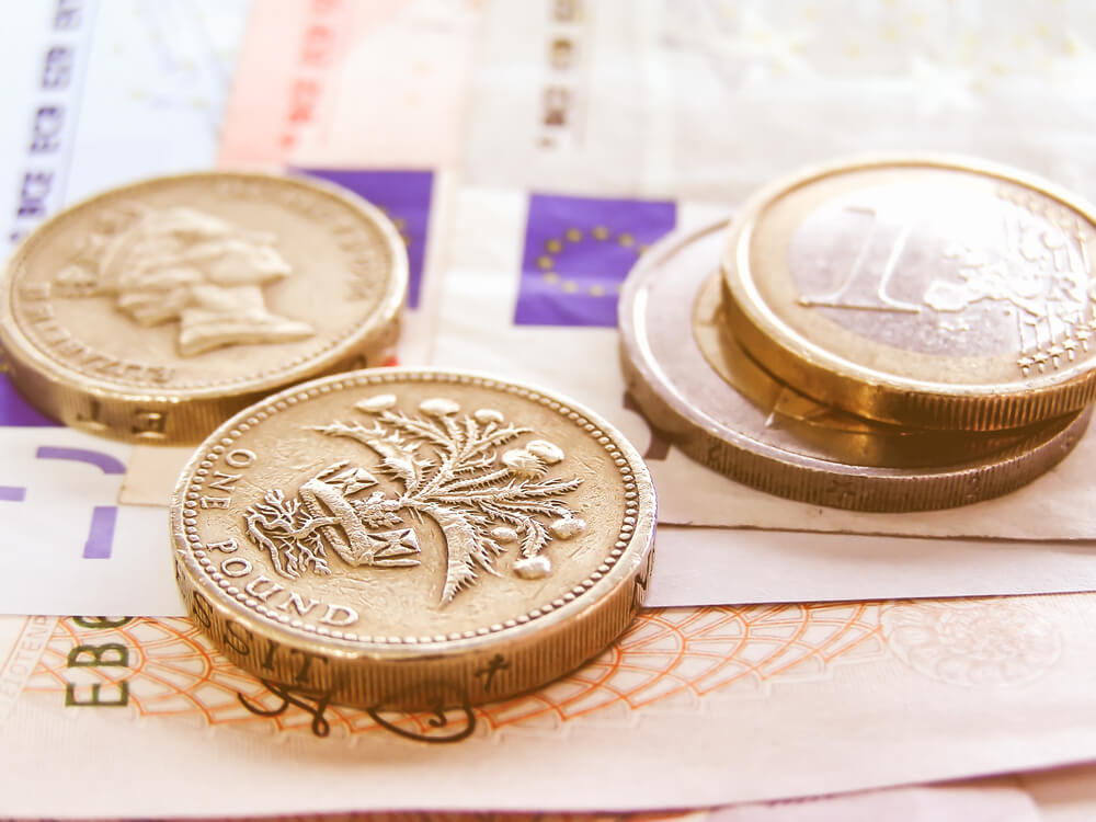 Wibest – GBPEUR: Detailed close up of a pound and euro bills and coins.