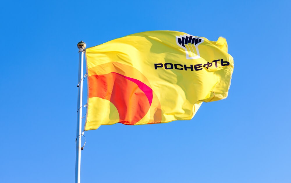 Rosneft: The flag of oil company Rosneft against blue sky.