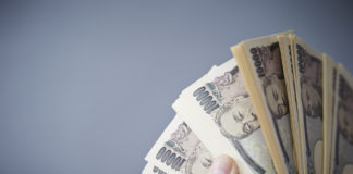Wibest – Japan Yen: Hands holding Japanese yen bills.