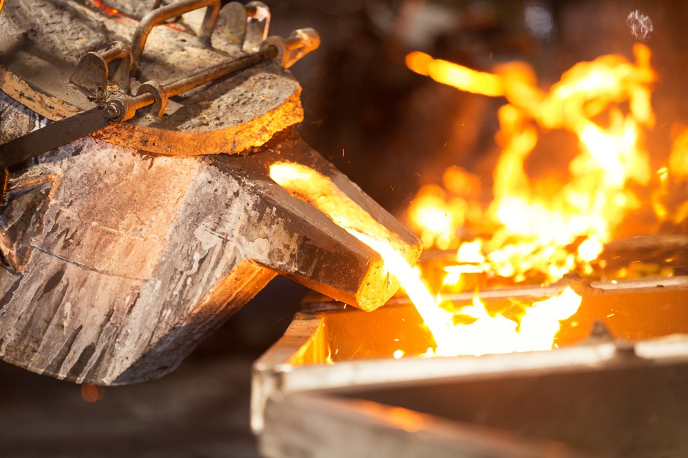 Wibest – Spot gold prices: A crucible pouring molten metal into a mold.