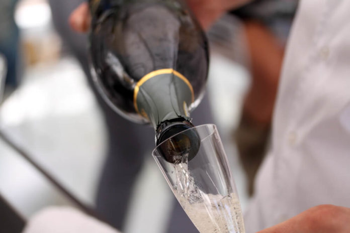 Wibest – European: A man pouring a bottle of Dom Perignon into a glass.