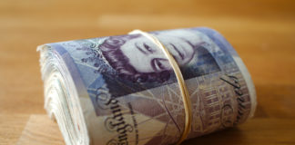 Wibest – GBP USD Exchange Rate: A roll of British pound sterling notes.