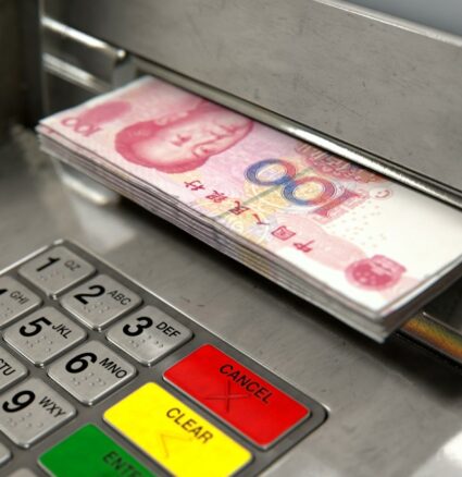 Wibest – USD to CNY: Chinese yuan bills coming out from an ATM machine.