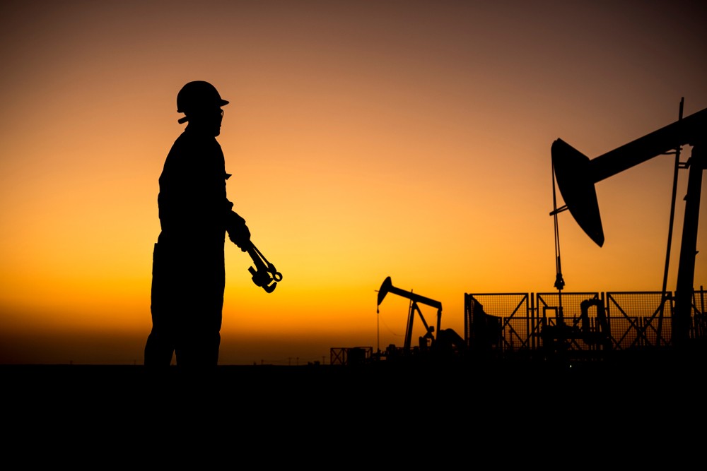 Wibest – OPEC Countries: A silhouette of an oil production worker.