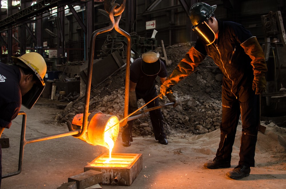 Wibest – Gold and Silver Prices: Three workers casting molten metal.
