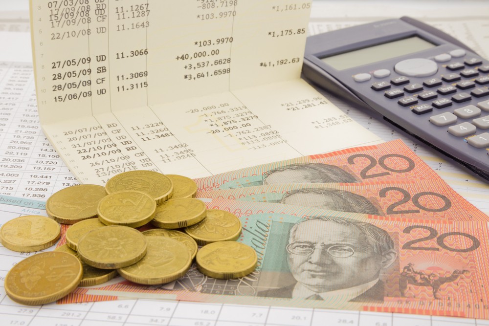 Wibest – Reserve Bank of Australia: Australian dollar bills and coins with a calculator, receipts, and trading chart.