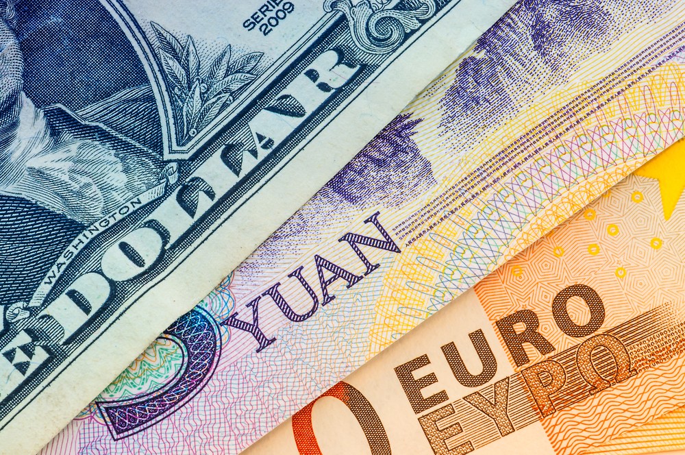 Wibest – Monetary Policy: A close up of the US dollar, yuan, and euro bills.