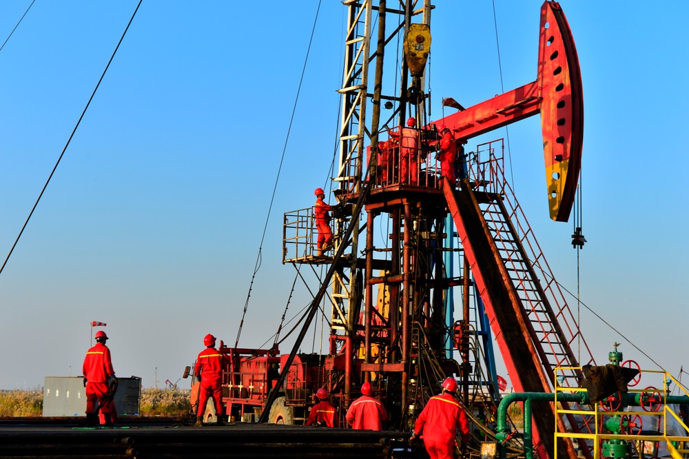 Wibest – Oil Petroleum: Crude oil pump jack with workers around it.