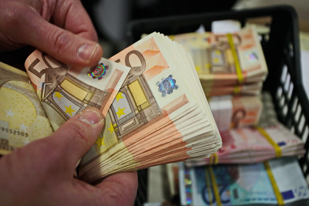 Wibest – Eurozone: A man counting euro bills.