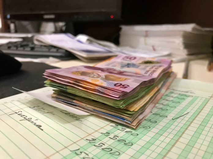Wibest – Mexican: Mexican peso bills on a desk.