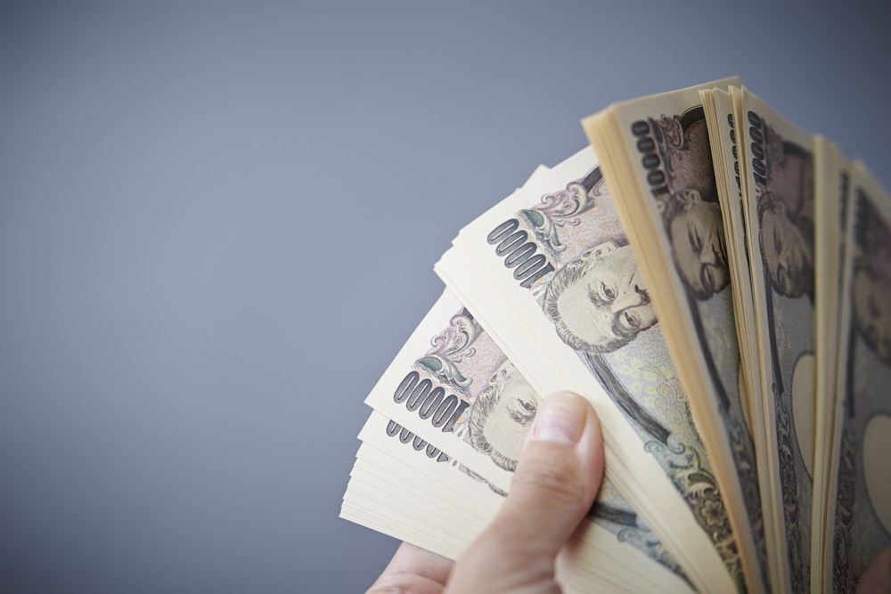 Wibest – Yen exchange rate: Hands holding Japanese yen bills.