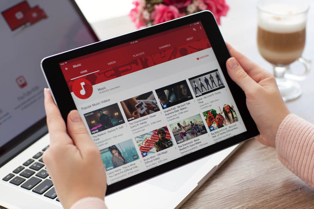 Woman holding a iPad with video sharing website YouTube on the screen.