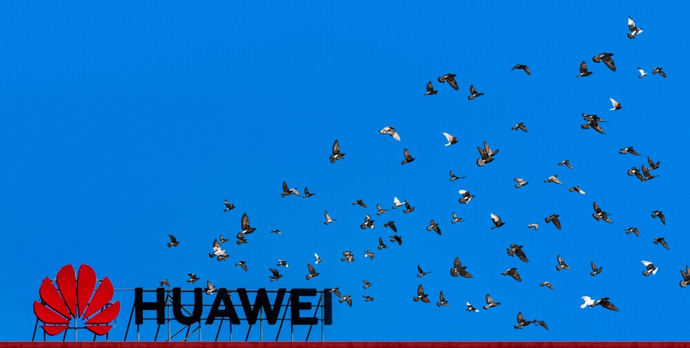 Huawei sign and logo on the roof of city building
