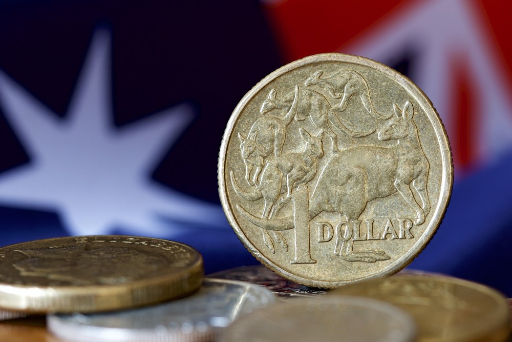 Wibest – Australian Money: Australian dollar coins and the Australian flag behind.