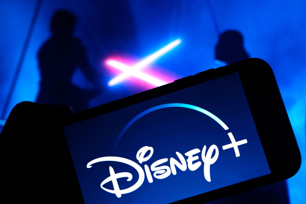 Disney Plus on smartphone screen with Star Wars in the background.