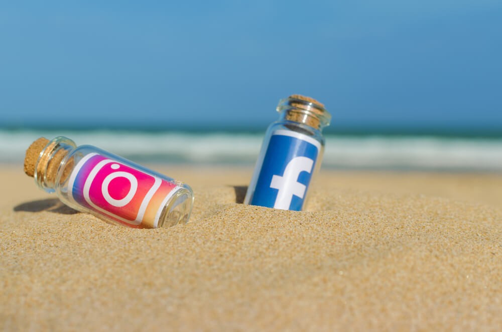 Facebook, Instagram printed on paper and placed in the sand against the sea.