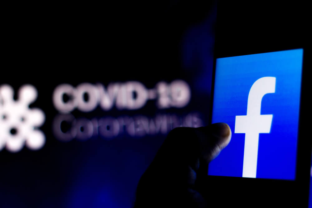 In this photo illustration the Facebook logo seen displayed on a smartphone with COVID-19 coronavirus in the background.