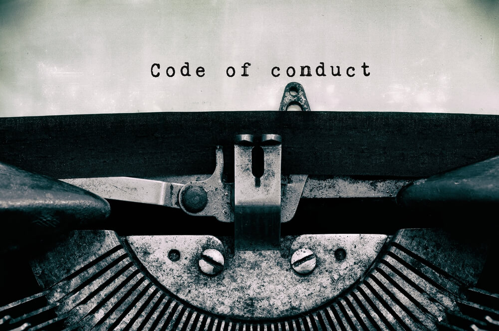  Code of conduct words typed on a vintage typewriter in black and white.