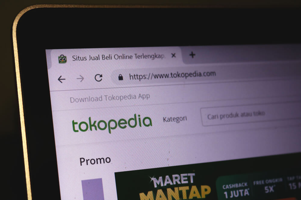 The homepage of the Tokopedia website is seen through a laptop screen.
