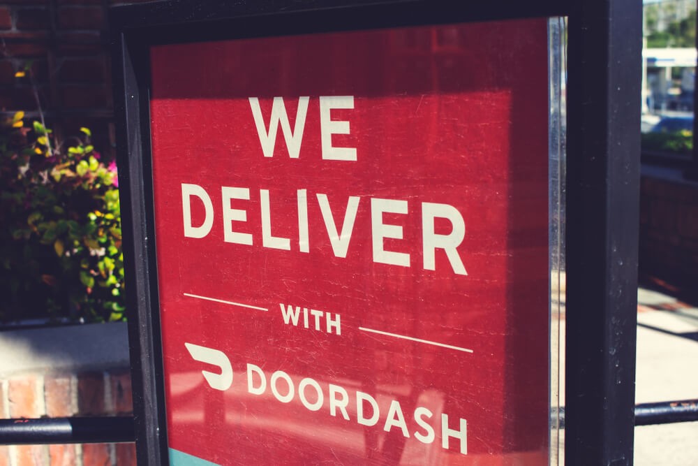 An advertisement at a restaurant offering food delivery service through the DoorDash app.
