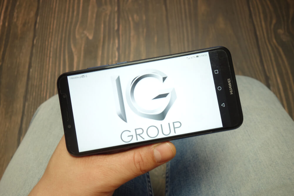 IG Group company logo displayed on Huawei smartphone.