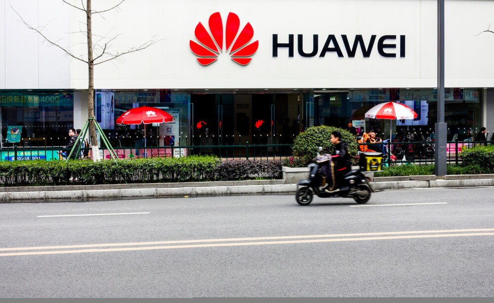 people passing by Huawei retail store