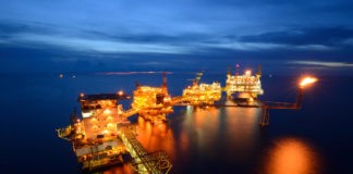 The large offshore oil rig at night with twilight background