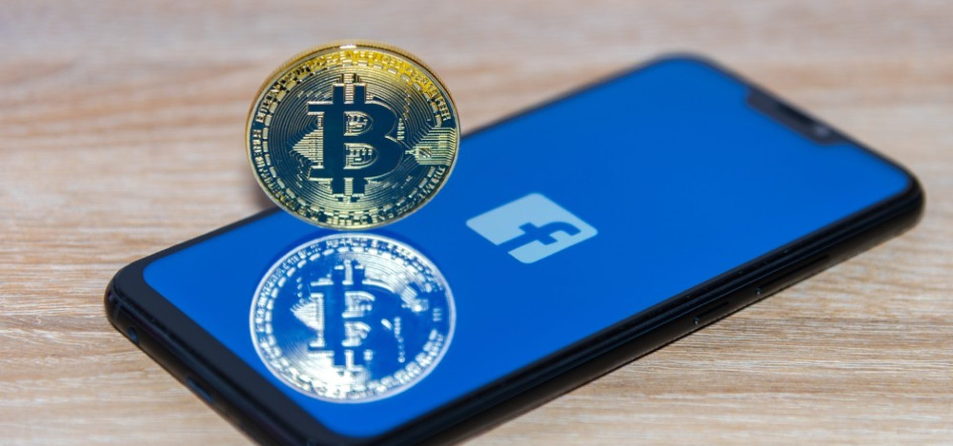 facebook logo with a bitcoin net to it on the phone
