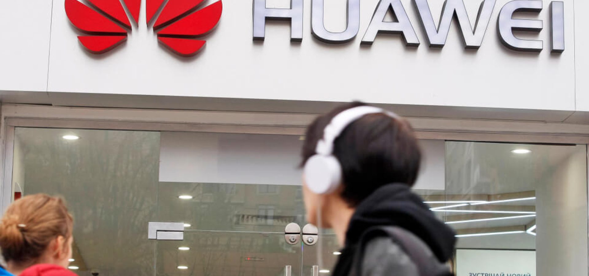 Wibest-Huawei: A man appears to look at the logo of Huawei.