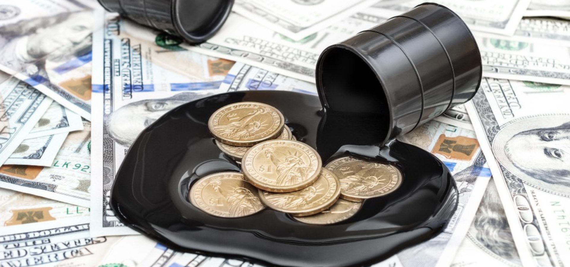 Wibest – Oil and petroleum: Oil barrel spilling crude over US dollar coins and bills.