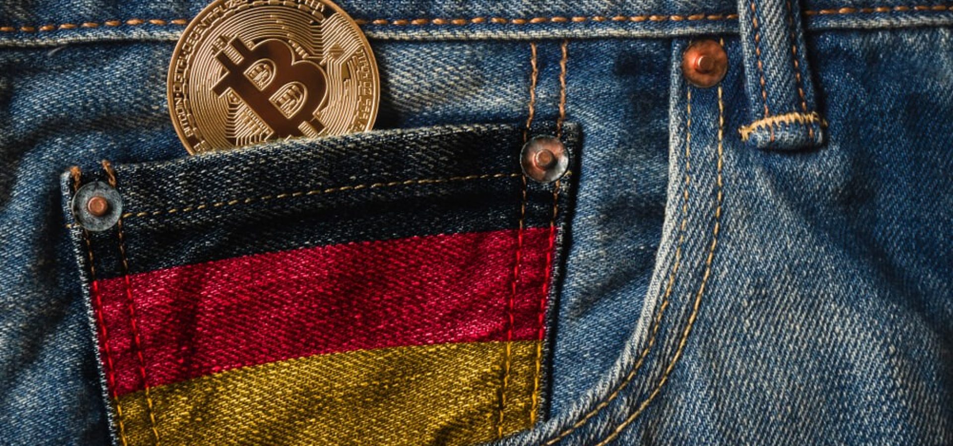 German: Golden BITCOIN (BTC) cryptocurrency in the pocket of jeans with the flag of Germany