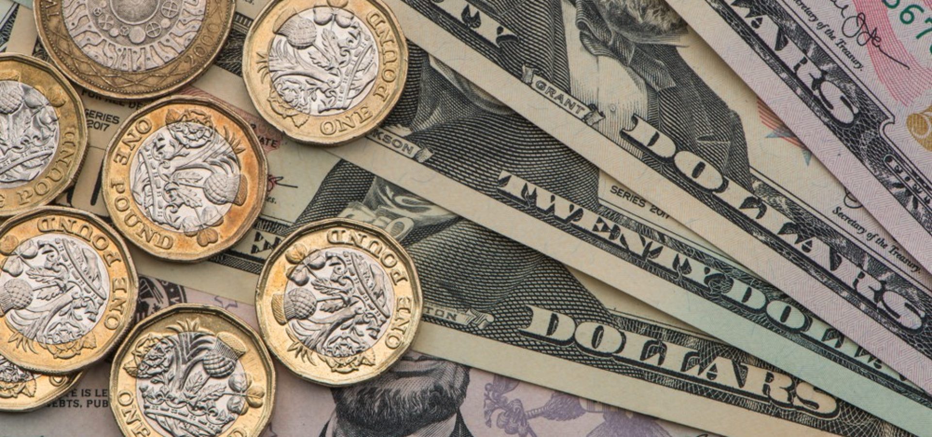 Wibest – GBPUSD: British pound sterling coins over US dollar bills.
