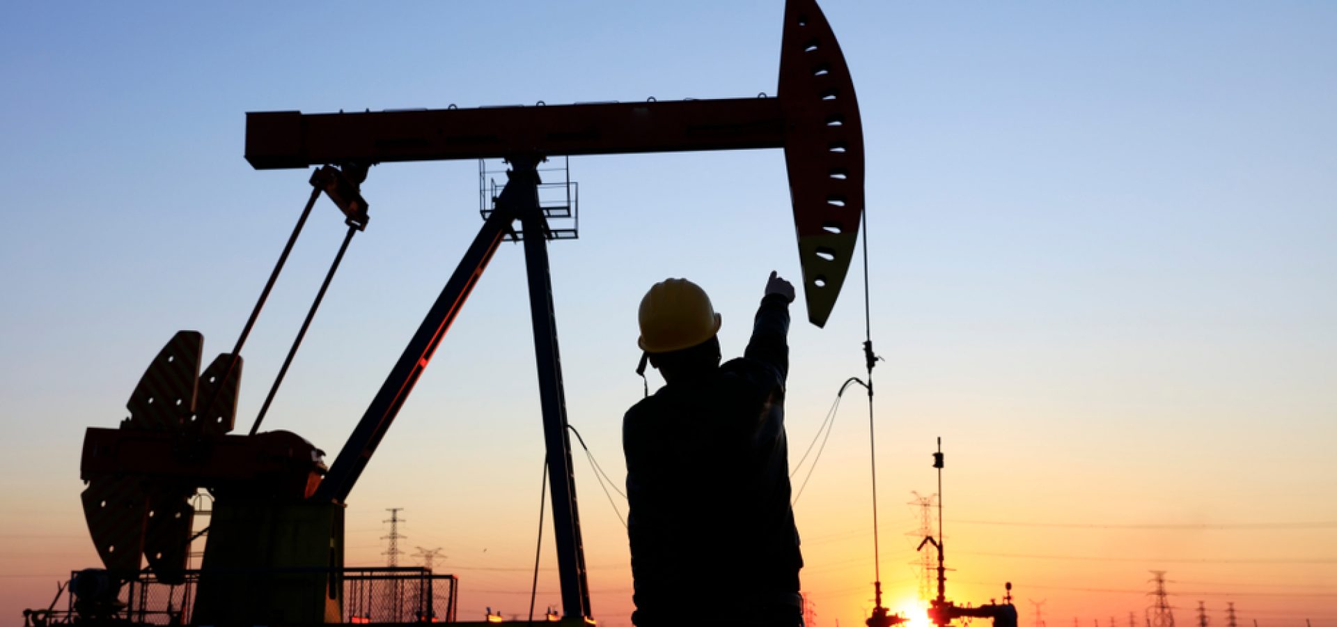 Wibest – Oil and Petroleum: A worker and an oil pump jack over the sunset.