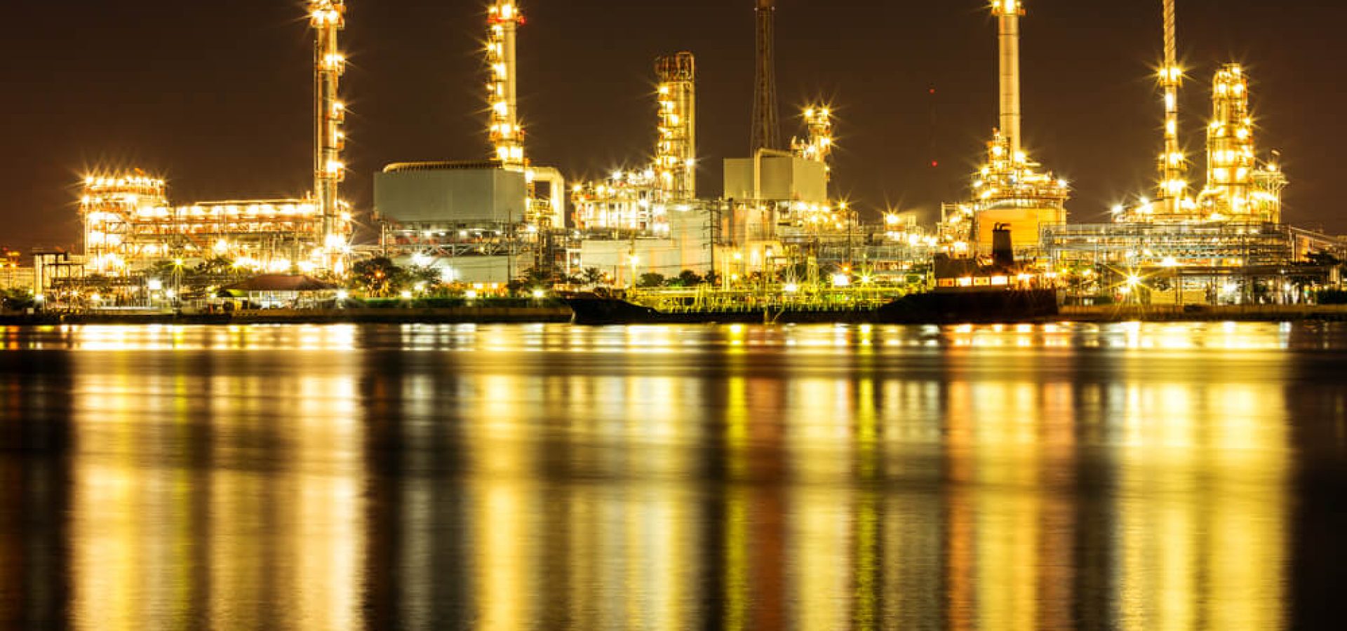 Oil Refinery Plant along river with tanker loading.