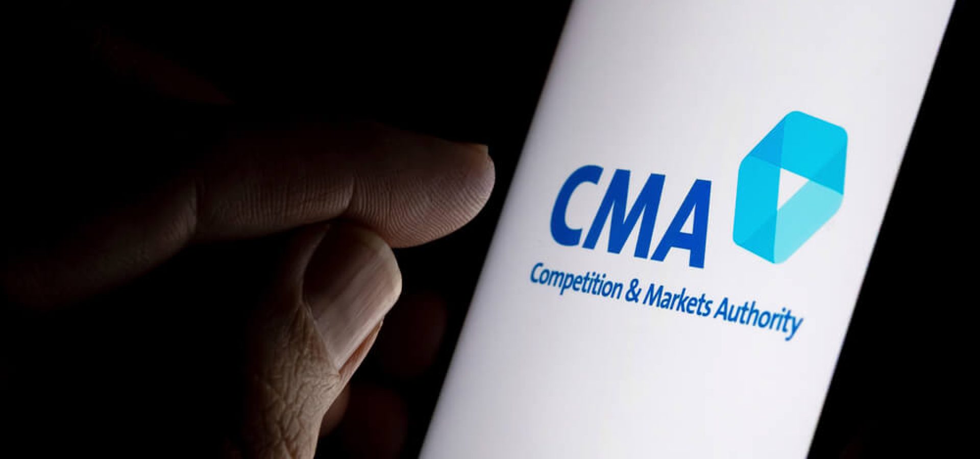 CMA Competition and Markets Authority logo on the screen and finger pointing at it.