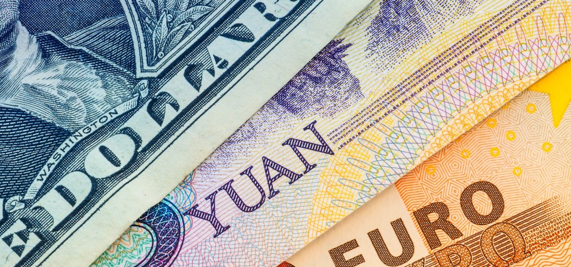 Wibest – Monetary Policy: A close up of the US dollar, yuan, and euro bills.