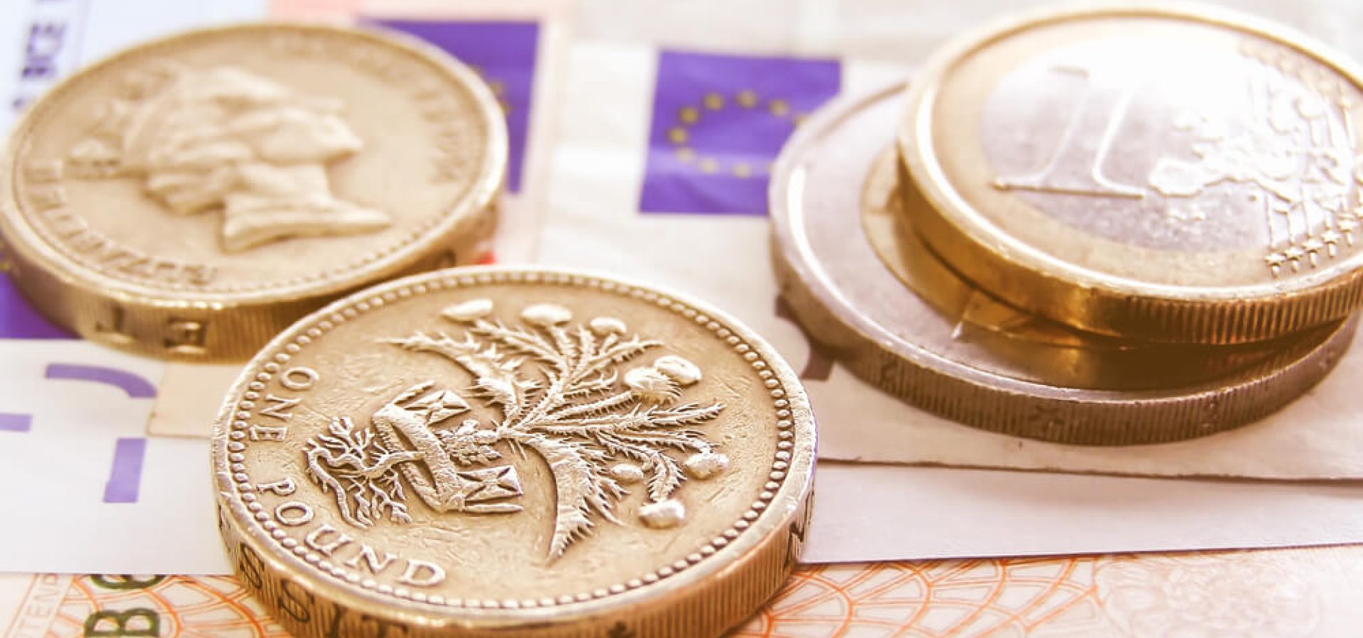 Wibest – GBPEUR: Detailed close up of a pound and euro bills and coins.
