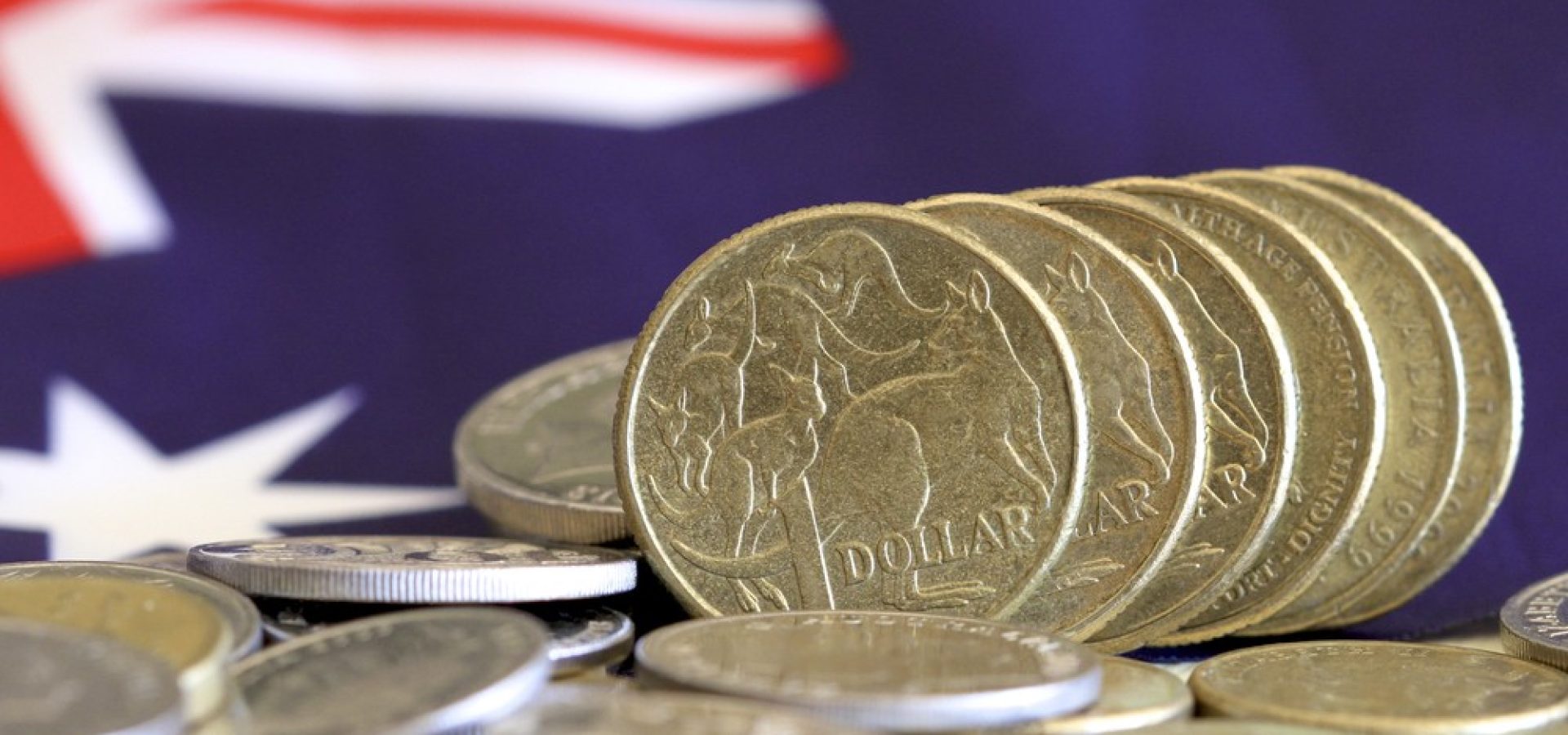 Wibest – Australian Money: Australian dollar coins over the Australian flag.