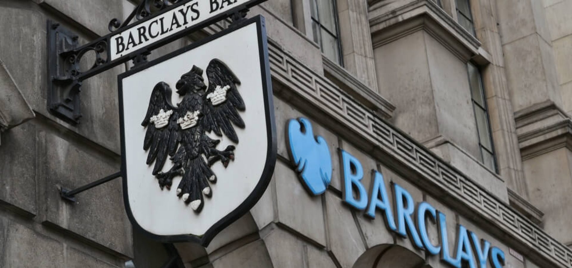 Barclays: Barclays bank old hanging street sign and modern logo next to it.
