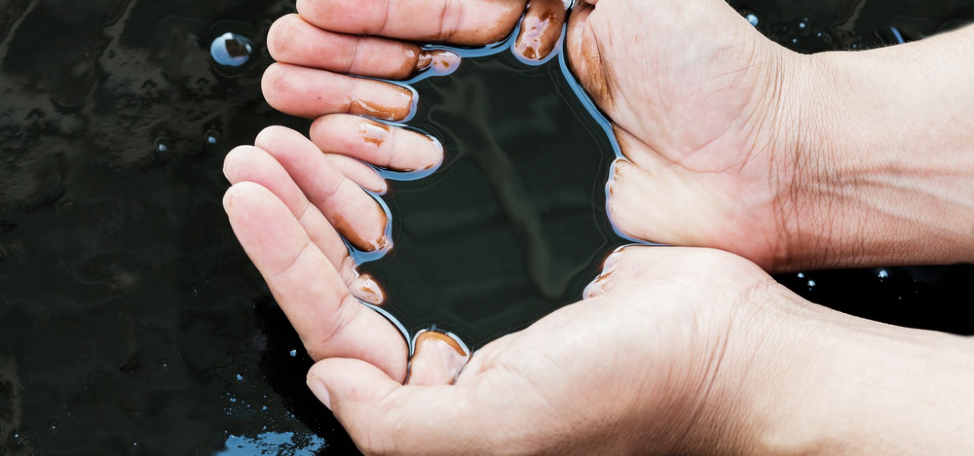Wibest – Oil and Petroleum: A man picking up crude oil with his bare hands.